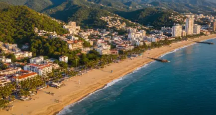 Vista panorámica de Puerto Vallarta en Jalisco con playas, mar azul y montañas verdes de fondo